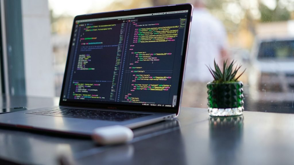 Developer's laptop showing code while migrating a website to cloud hosting
