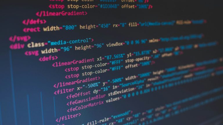 Colourful lines of code glowing on a dark editor screen, representing cross-platform app development