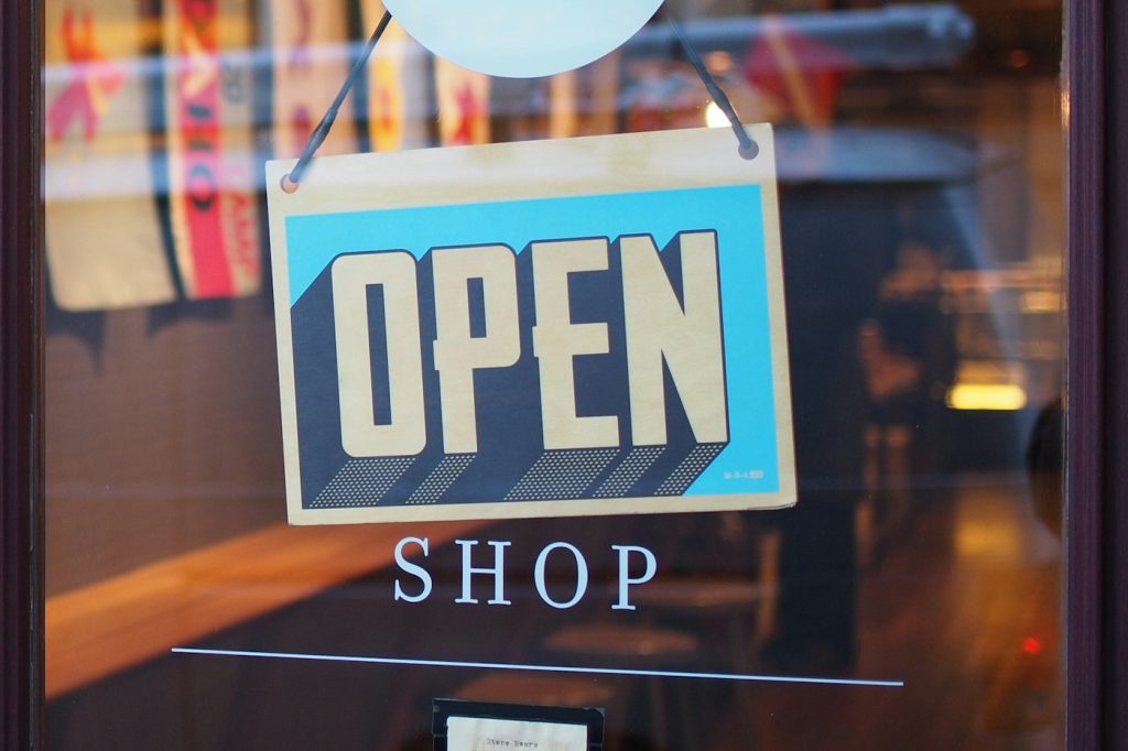 Open sign hanging in the window of a small local shop
