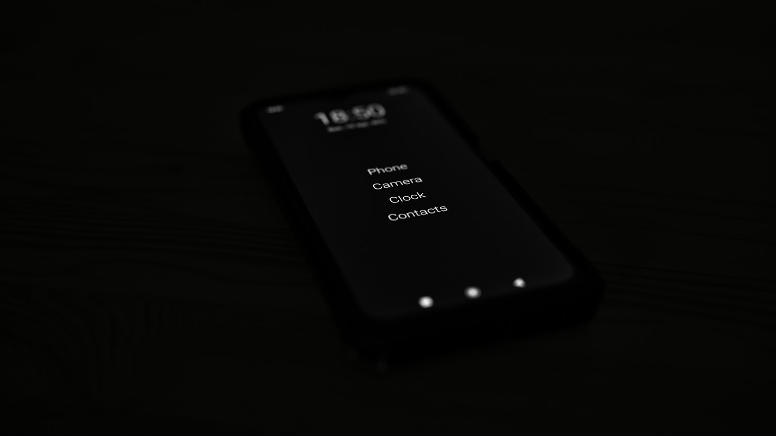 Smartphone with a minimal home screen glowing in the dark, representing a finished mobile app product