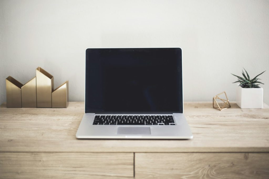 Laptop on a tidy wooden desk, set up for working through a website launch checklist