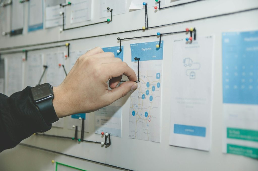 Team member arranging paper notes on a board to map out a site structure