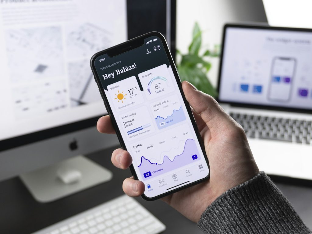 Person testing a mobile app prototype with a data dashboard on a smartphone