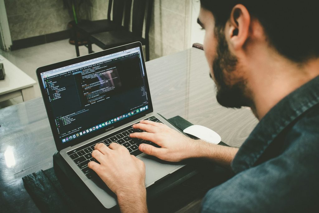 Web developer working on website code updates on a laptop